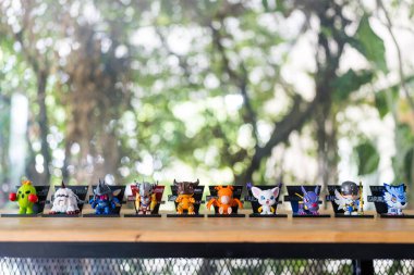 Bangkok, Tayland - 2 Mayıs 2025: Pop Mart 'tan Digimon Macera Macerası Mıknatıs Serisi Figürleri, doğaya karşı ahşap masa üzerinde dizilmiş