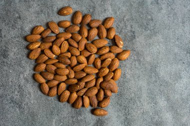 Karanlık bir arka planda bir yığın badem.