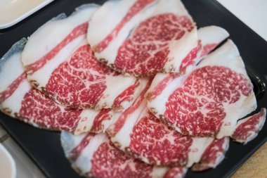 Sukiyaki için ince dilimlenmiş sığır eti yakın çekim yüksek dereceli mermer ile, kırmızı et boyunca karıştırılmış karakteristik zengin, karmaşık yağ deseni göstermek