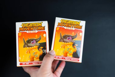 Bangkok, Tayland - 12 Mayıs 2025: Elinde oyuncak Digimon Macera Dolapları Serisi figürleri, siyah arka planda pop market.