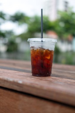 İçtikten sonra ahşap masanın üzerindeki buzlu kahveyi kapat..