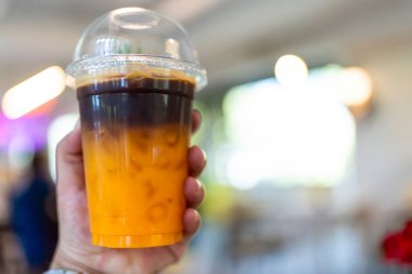 Buzlu kahve portakallı americano füzyonu ve taze portakal suyu elinizdeki plastik bardakta karıştırılmış.