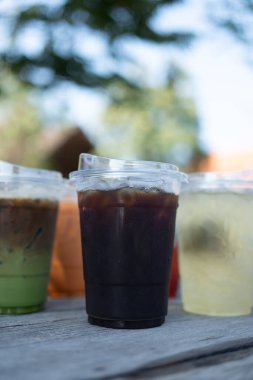 Önünde buzlu kahve, arka planında buzlu içecek, farklı içki.