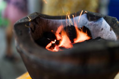Parlak ateş alevleriyle ızgara kömür ızgarası. Tay geleneği tarzında kömür toprağı sobası. Tayland yemeği pişirmek için kullanılır.