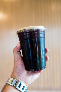 Elinde sade buzlu kahve. Tazeleyici içecek.