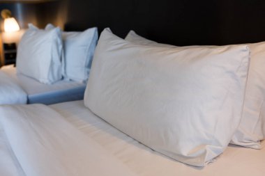 Modern otel odasındaki beyaz yastıklı ikiz yatağı kapat. Yatmaya hazırım. Güzel ikiz yatak.