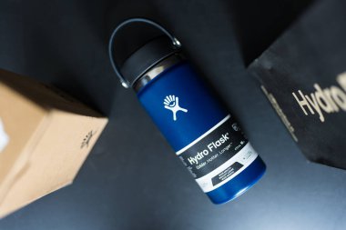 Bangkok, Tayland - 6 Haziran 2025: Hydro Flask su şişesi, çivit rengi geniş ağız fleksi kapağı. Metal içecek kabı, çevresel ürün.