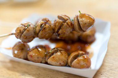 Izgara köfte, bambu, tatlı ve acı biber soslu tepsi kutusunda servis edilir.