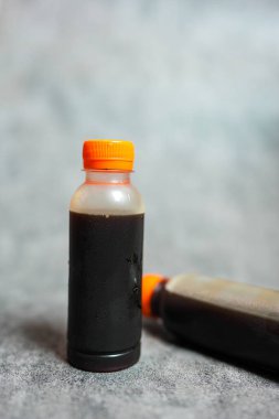 Gri arkaplanda lezzetli soğuk bir bira şişesi.