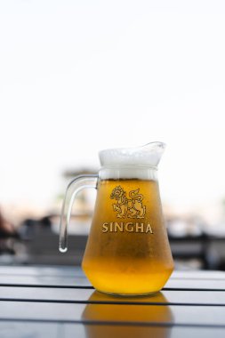 Bangkok, Tayland - 9 Haziran 2025: Tahta masada bir sürahi soğuk Singha birası, orijinal Tayland birası