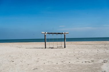 Tropik yaz plajında güzel ahşap salıncak manzarası. Yaz Tatili Seyahat ve Tatil Konsepti.