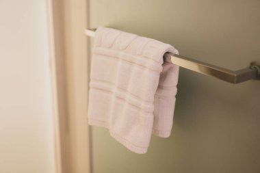 Kapı kolunda asılı beyaz bir ayak havlusu rahatlık ve temizliği işaret ediyor. Otel işleri.