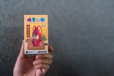 Bangkok, Tayland - 18 Haziran 2025 Oyuncaklar pastel boya kalemi Shinchan gıda malzemeleri serisi insan eli üzerindeki kör kutu