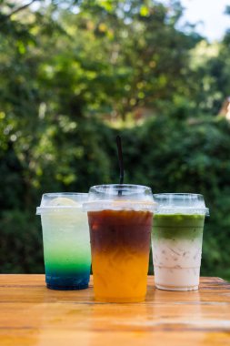 Serinletici bir renk karışımı sergilenen üç bardak ferahlatıcı içecek. Bir yaz günü için mükemmel, bu renkli içecek rahatlamaya davetiye çıkarıyor. Arkadaşları bir araya getirip eğlenmeye davet etmek.