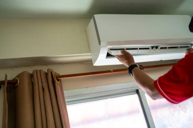 Erkek teknisyen içeride klimayı temizliyor, tamirci kirli bölmeleri yıkıyor klimayı yıkıyor, bakım ve tamir kavramlarını tamir ediyor.