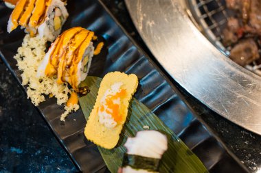 Izgaranın yanında bir sürü suşi çeşidi olan bir masa. Üst görünüm