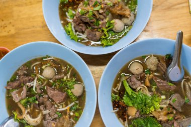 Üç mavi kase et tendon köftesi çorbası ile pişirilmiş biftek. Üst görünüm