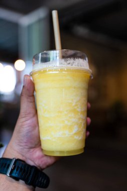 Lezzetli ananas püresiyle dolu şeffaf bir plastik bardak.