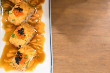 Havyarla kaplı lezzetli suşi somon ruloları. Üst görünüm