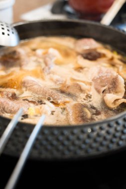 Sıcak ve kaynayan Shabu çorbası, sıcak tencerede et ile doldurulur.