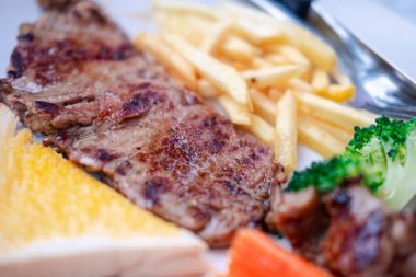 Kızarmış biftek, patates kızartması ve karışık sebze. Seçici odak