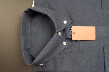 Klasik katlanmış koyu mavi kıyafetler ve kırmızı kağıt etiket. Üst görünüm