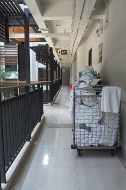 Otel koridorunda oda malzemeleri ve temizlik malzemeleriyle dolu bir tramvay.