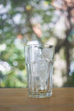 Buzlu temiz bir bardak içinde doğa arka planına karşı.