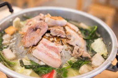 Cızırdayan sıcak Mookata, Tayland usulü ızgara domuz eti ve sıcak tava. Fırında kızartılmış taze, marine edilmiş domuz eti ve sebzeler. Lezzetli ve dumanlı bir yemek, arkadaşlarınız ve ailenizle paylaşmak için mükemmel..