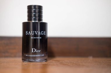 Bangkok, Tayland - 12 Temmuz 2025: Tahta masadaki Dior Sauvage parfümünün dikey çekimi