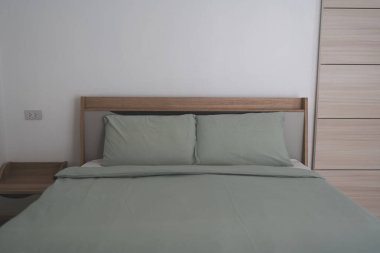 Yeşil yastıklar bir yatakta, yeşil bir yeşil yatak yeşil yastık örtüsü, çarşaf ve battaniye ile yeni bir evde