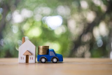 Ahşap araba ve ev modeline bozuk para yığmak. Gelecek için ev konsepti almak için para biriktir ve yatırım yap. Yatırım için para biriktiriyorum