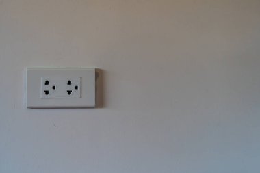 Beyaz beton arka planda fotokopi alanı olan modern çift elektrik prizi prizi prizi.
