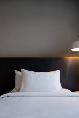 Modern otel odasında yatak başucunda lambalar olan temiz bir yatak. Yatmaya hazırım..