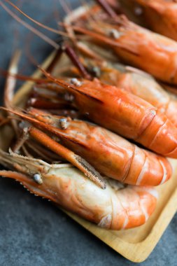 Kral karidesler ahşap tepside servis edilir, deniz ürünleri yosunu batırarak yapılan yaygın bir yemektir.