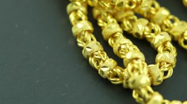 Siyah bir arkaplanda altın kolye ya da altın bilezik rotasyonu