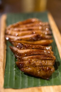 Muz yaprağında servis edilen Tayland kömürü haşlanmış domuz boynu.