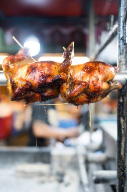 Kavrulmuş tavuk kızartma fırınında tükürük açıyor, Tayland restoranında çıtır çıtır, kahverengi derisini sergiliyor.