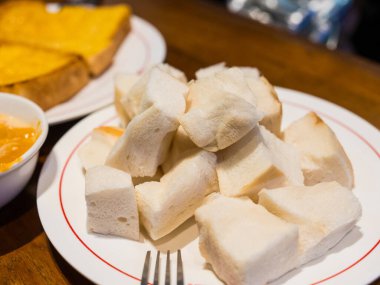 Dilimlenmiş ekmeği beyaz tabakta yakın..