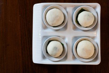 Seramik tabakta servis edilen dört parça Tayland mochi 'si. Üst görünüm