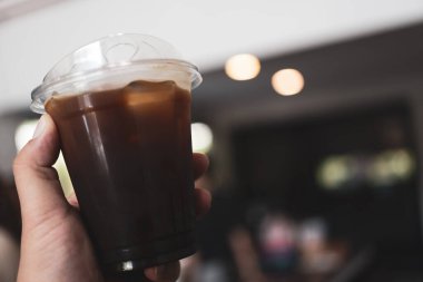 Paket bardakta soğuk Americano kahvesi tutuyorum.