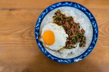 Pad Kra Pao Tayland usulü sahanda yumurtayla kaplanmış biftek ile karıştırılmış kutsal fesleğen. Thai phat kaphrao pilavı