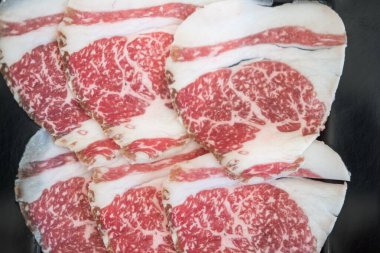 Sukiyaki için ince dilimlenmiş sığır eti yakın çekim yüksek dereceli mermer ile, kırmızı et boyunca karıştırılmış karakteristik zengin, karmaşık yağ deseni göstermek