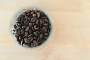 Ahşap masada cam kavanozdaki kahve çekirdekleri. Üst görünüm