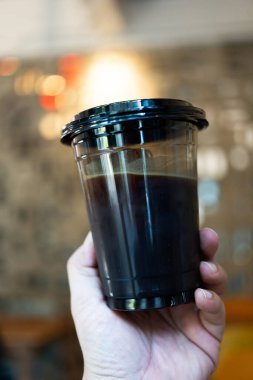 Bir fincan siyah kapaklı buzlu Americano.