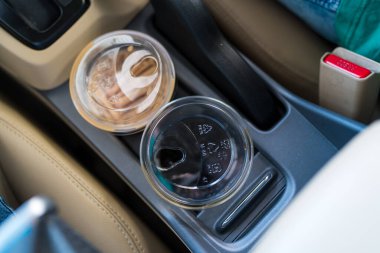 Araba fincanı tutacağında iki bardak buzlu kahve var. Araba kullanırken kahve içmek..