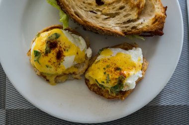 Tembel bir sabahta nefis bir tabak yumurta Benedict, mükemmel bir yumurta durdurma, altın, çıtır patates, eğlenmeye hazır.