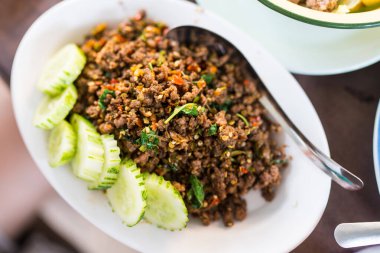 Tayland usulü kıyılmış biftek ve dilimlenmiş salatalıkla servis edilen kutsal fesleğen.