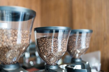 Kahve dükkanında içinde kahve çekirdekleri olan üç kahve öğütücüsü..