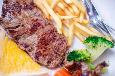 Biftek ve meze ile servis edilen ızgara biftek. Kapat.